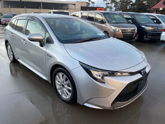 2020 Toyota Corolla Touring 1.8 4WD Hybrid S Station Wagon in silver with rain droplets, showcasing its sleek design.