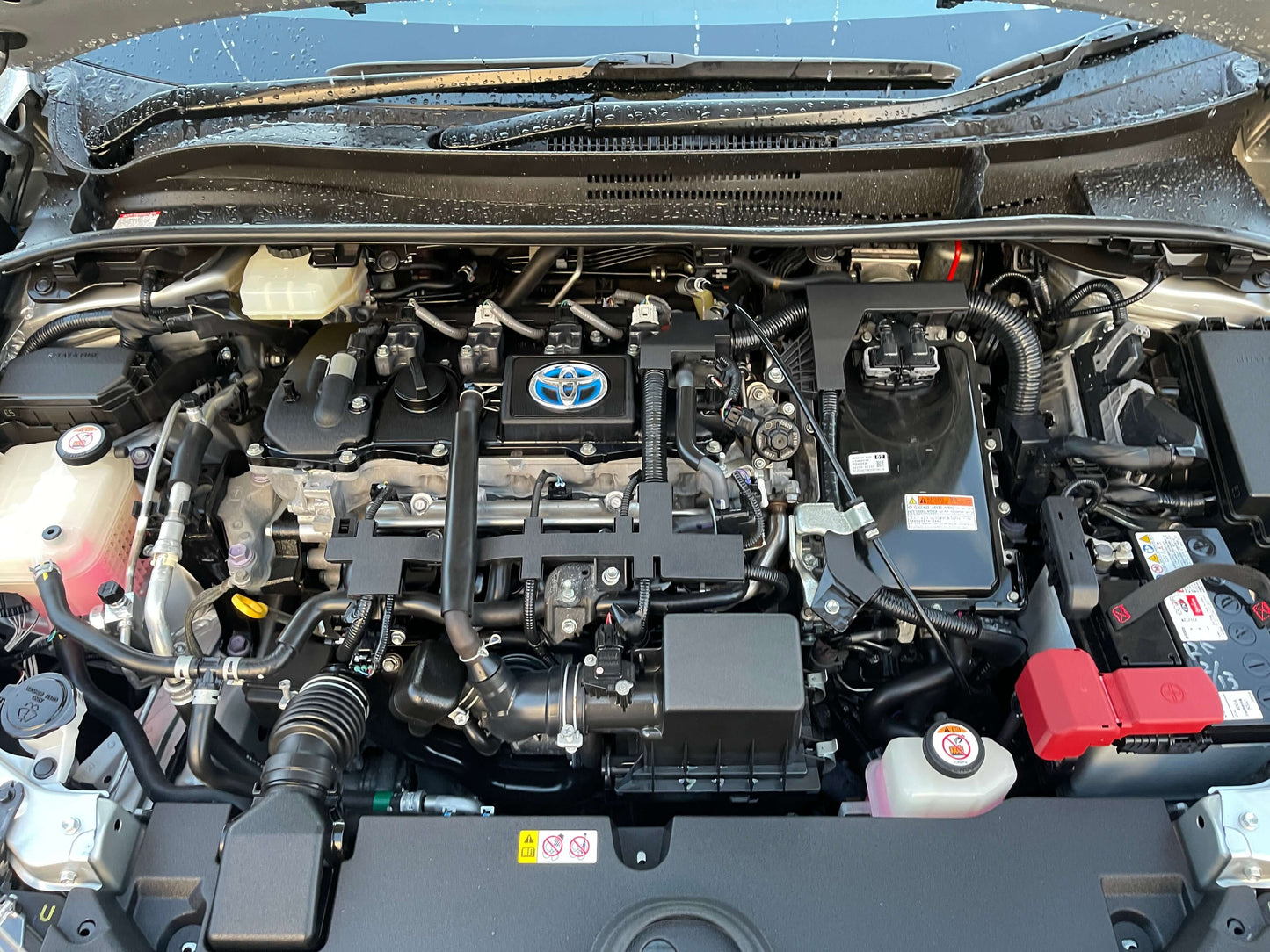 Engine bay of a 2020 Toyota Corolla Touring 1.8 4WD Hybrid S Station Wagon showing detailed components.