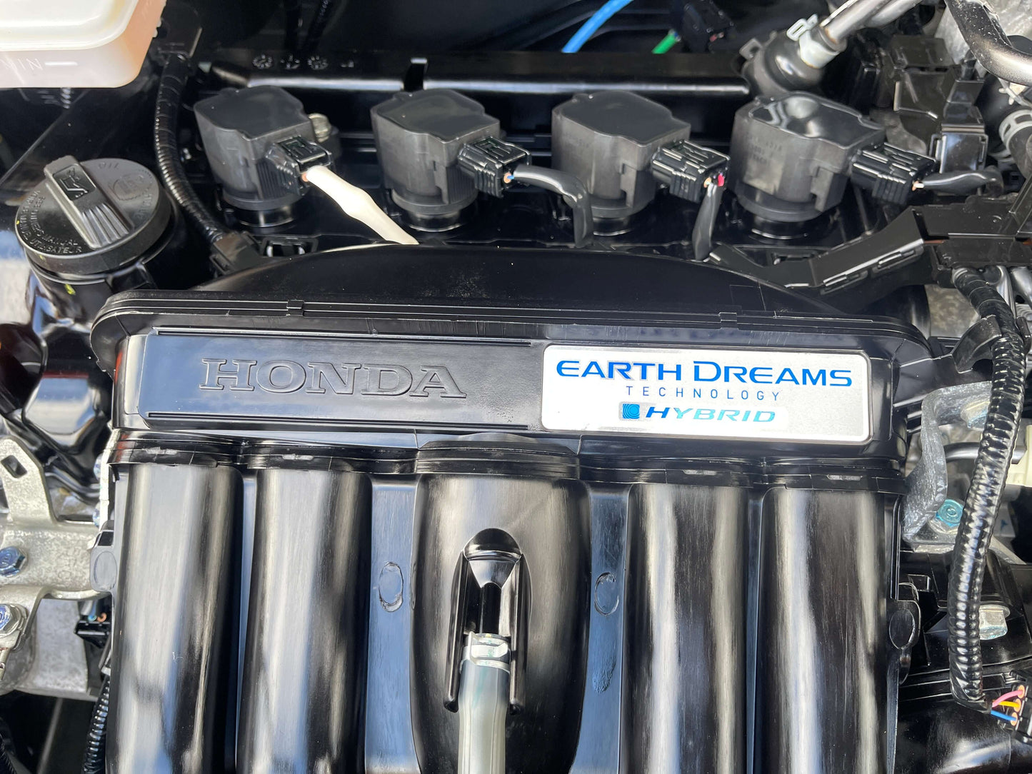 Close-up of the Honda engine with Earth Dreams Technology label, showcasing hybrid technology for 2019 Honda Shuttle Hybrid.