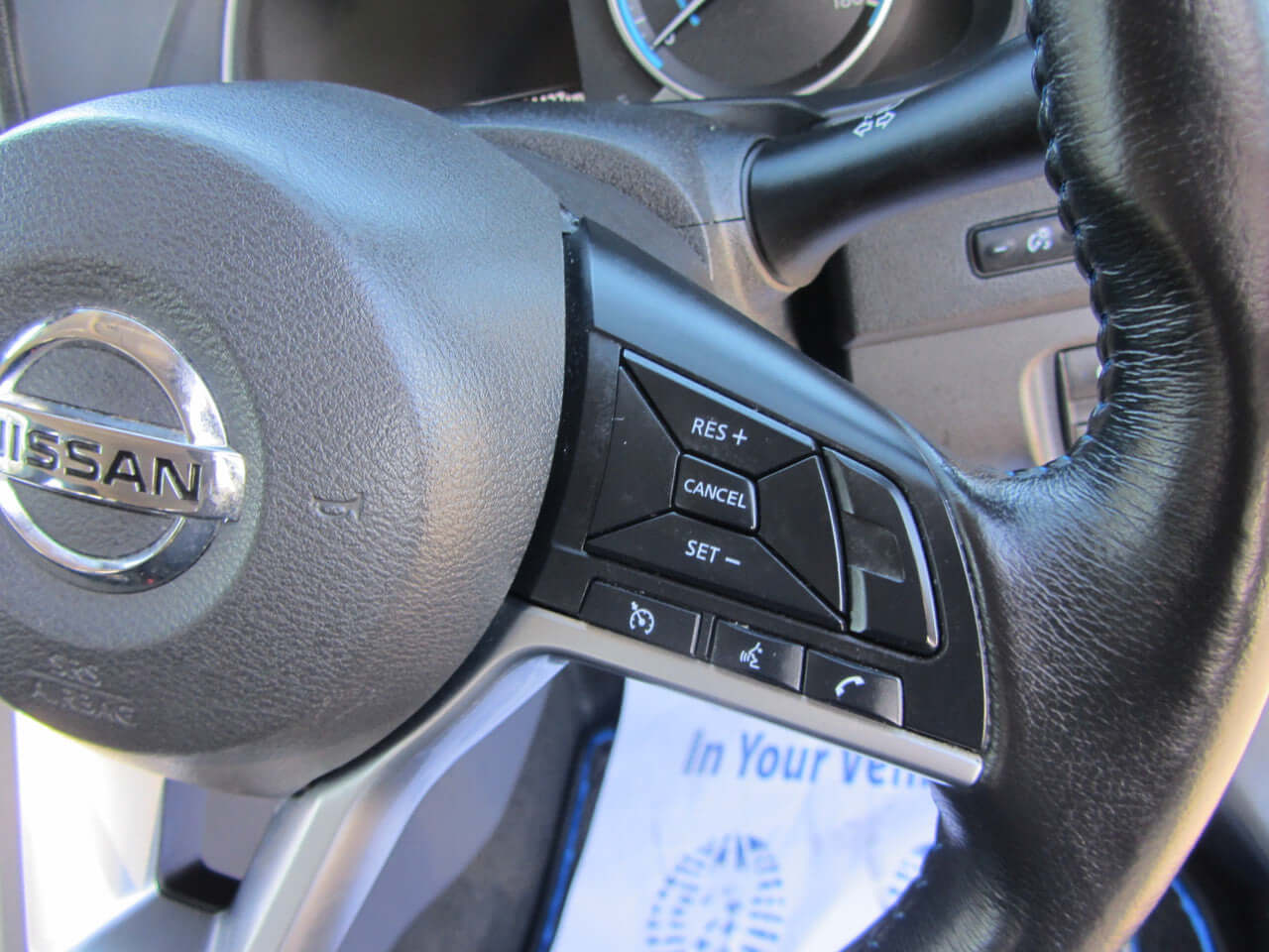 Close-up of steering wheel controls in the 2019 Nissan Leaf e+ 62kW X-Edition Full Electric, featuring buttons for cruise control.