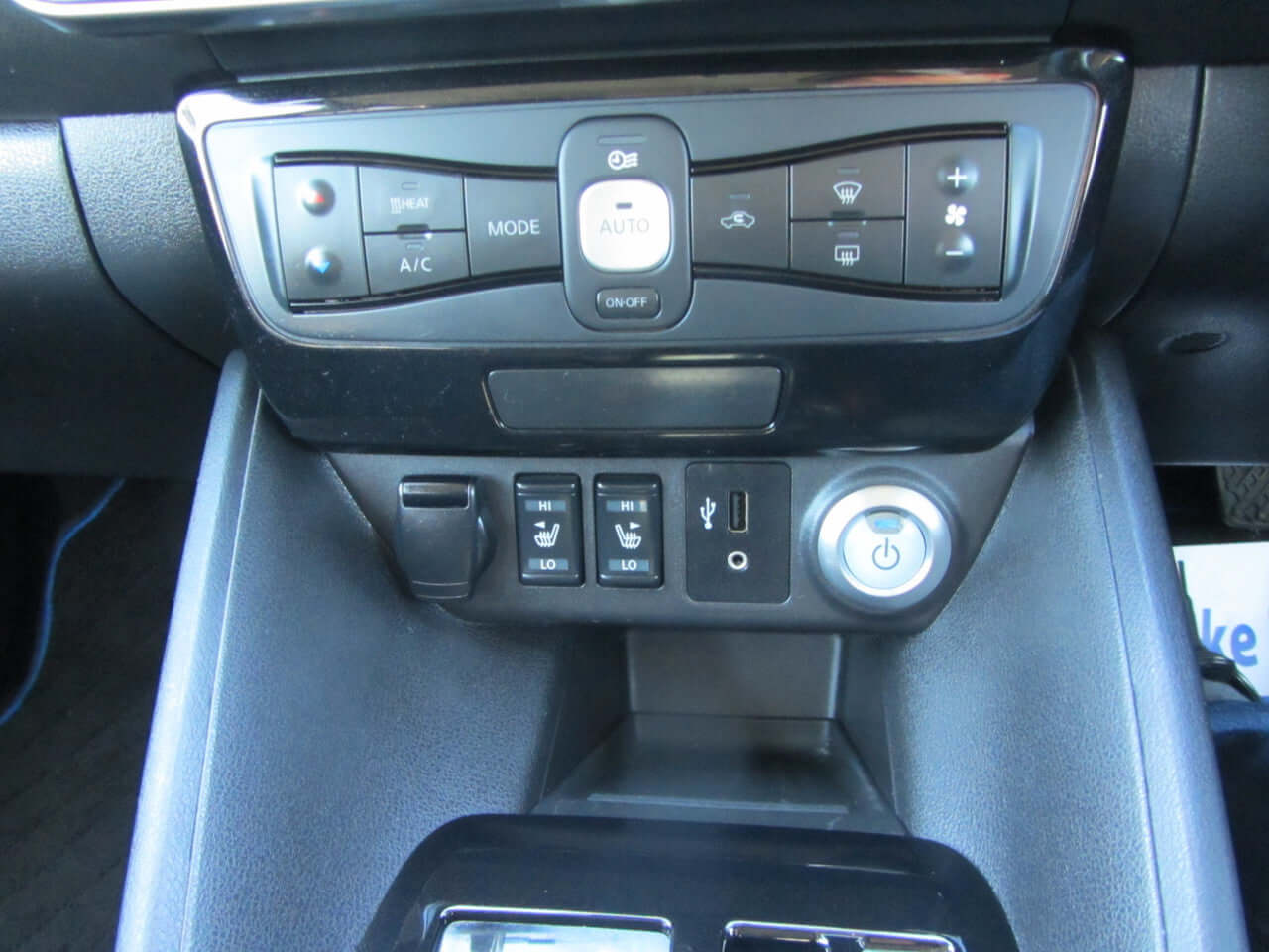 Interior controls of the 2019 Nissan Leaf e+ 62kW X-Edition Full Electric, featuring climate controls and charging ports.