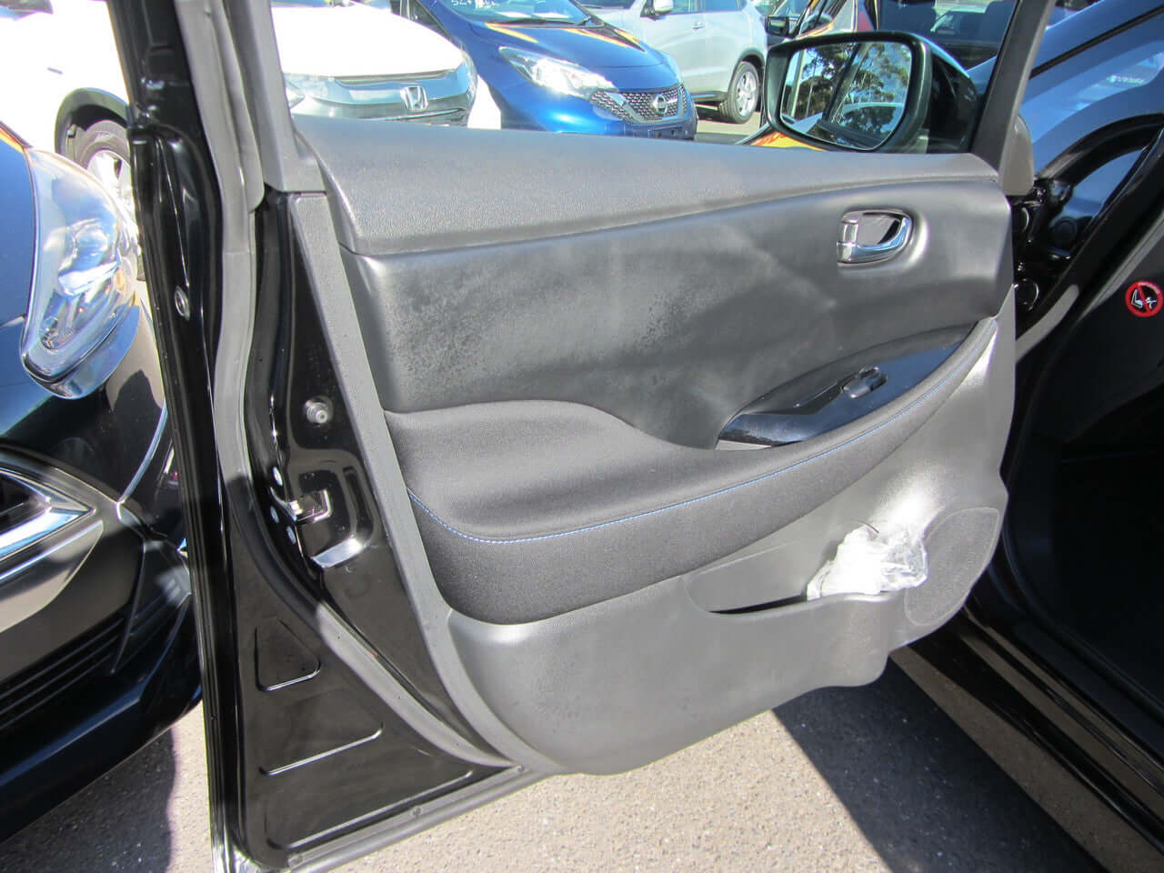 Interior view of the passenger door of a 2019 Nissan Leaf e+ 62kW X-Edition Full Electric showing features and design.
