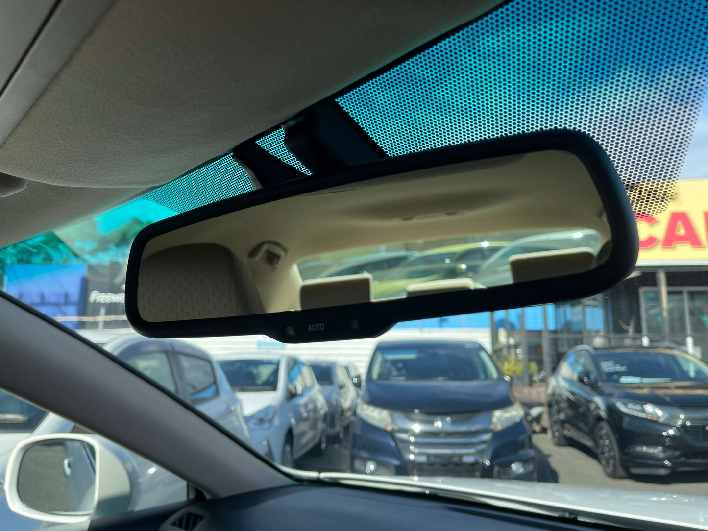 2008 Toyota Crown V6 3.0L Interior view of a car's rearview mirror showing cars parked in the background.