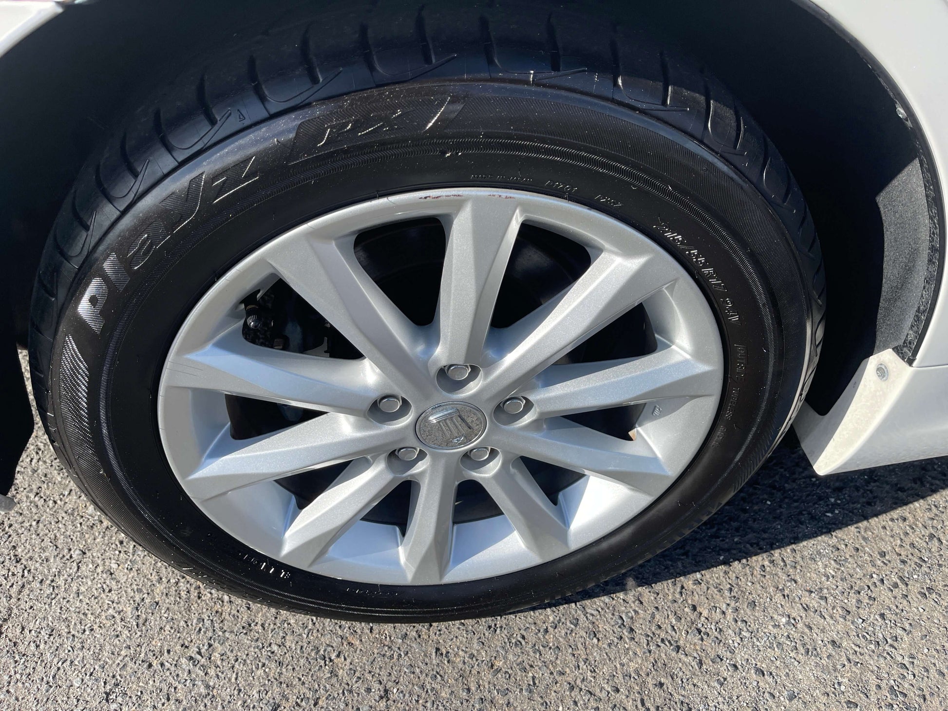Close-up of a silver alloy wheel and tire of a 2008 Toyota Crown V6 3.0L Royal Saloon Luxury Sedan.