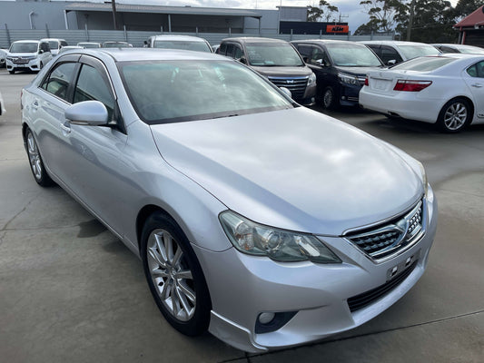 2010 Toyota Mark X V6 3.5L 350S Sport Sedan parked in a lot with other cars in the background.