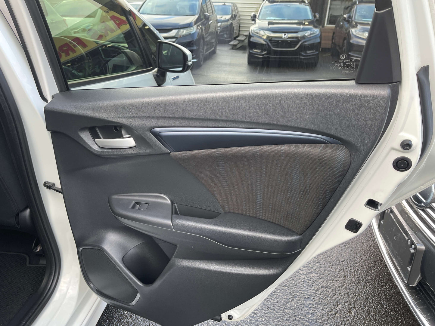 Interior view of the 2021 Honda Shuttle Hybrid X Honda Sensing Edition door panel, showcasing modern design features.