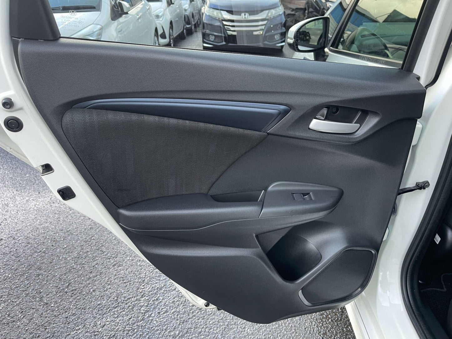 Interior view of the 2021 Honda Shuttle Hybrid door panel showcasing stylish design and functional controls.