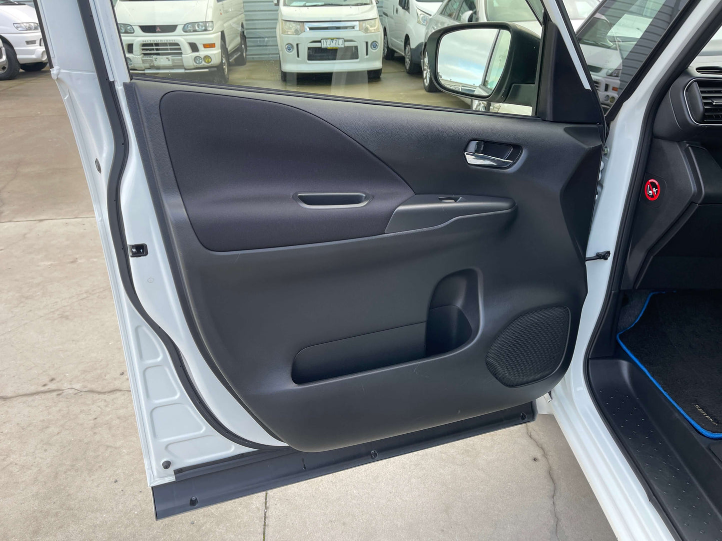 Interior view of the 2018 Nissan Serena 1.2 e-Power Highway Star V door panel with sleek design and controls.