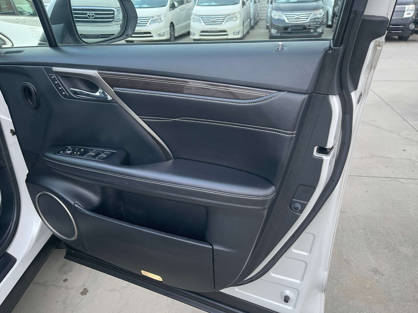 2017 Lexus RX450H luxury SUV interior door panel with controls and premium materials.