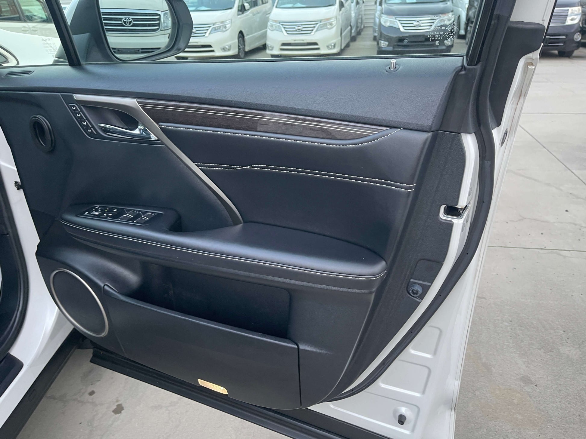 2017 Lexus RX450H luxury SUV interior door panel with controls and premium materials.