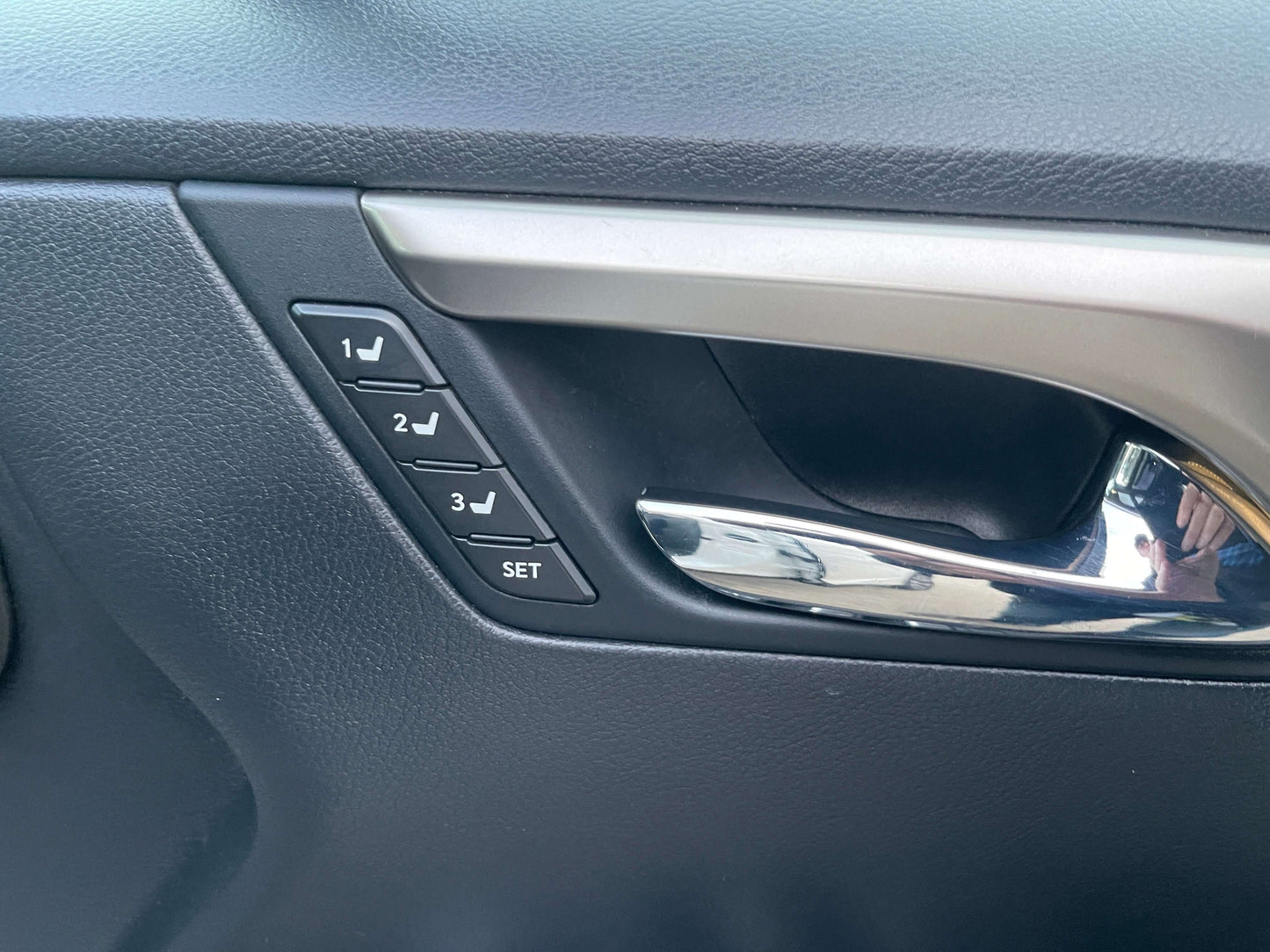 Door lock and window control buttons with memory settings in the 2017 Lexus RX450H luxury SUV.