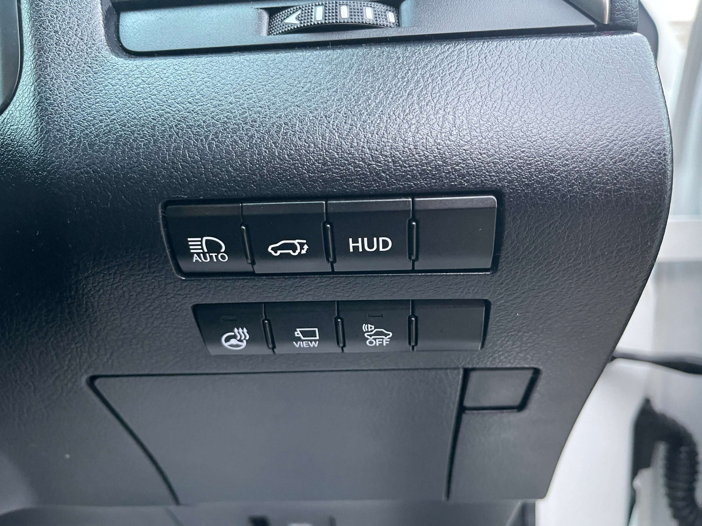 Control buttons on the dashboard of a 2017 Lexus RX450H for HUD, auto, and view.