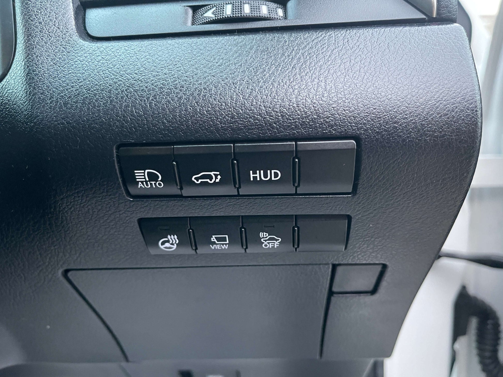 Control buttons on the dashboard of a 2017 Lexus RX450H for HUD, auto, and view.