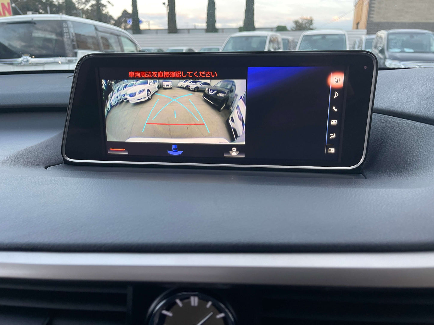 2017 Lexus RX450H displaying rearview camera with parking guidelines on dashboard screen.