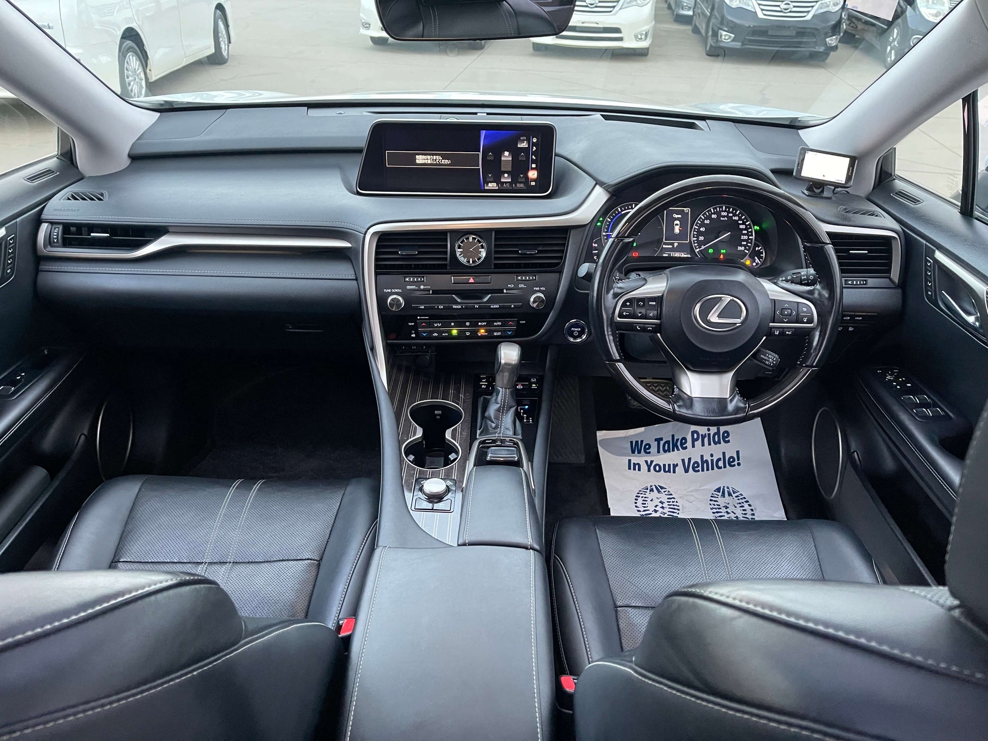 Interior view of the 2017 Lexus RX450H with modern dashboard, steering wheel, and leather seats.