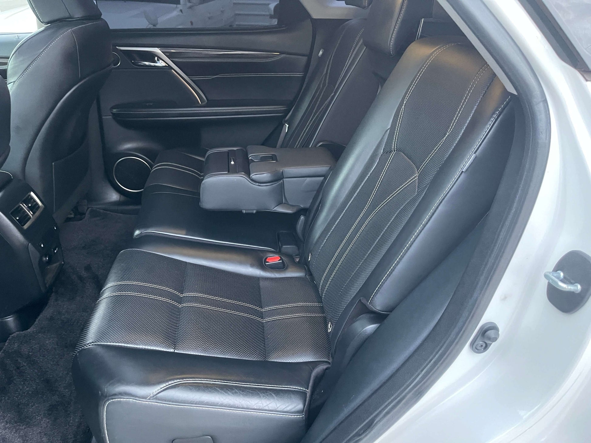 Interior view of the backseat of a 2017 Lexus RX450H V6 3.5L Hybrid L Version luxury SUV with black leather upholstery.