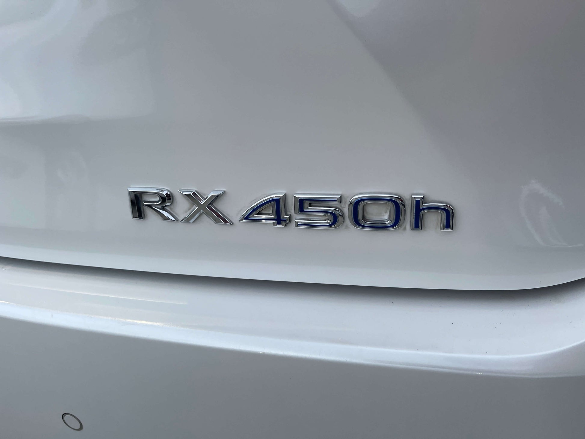 Close-up of the RX450h badge on the rear of a 2017 Lexus RX450H luxury hybrid SUV