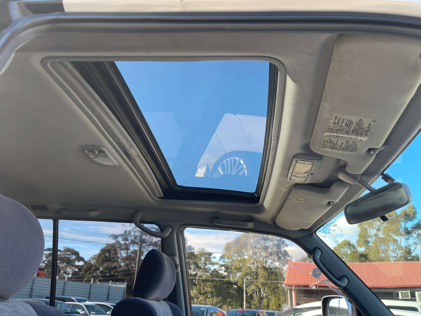 Interior sunroof view of a 1996 Toyota Land Cruiser Prado V6 3.4L, showcasing a spacious cabin.