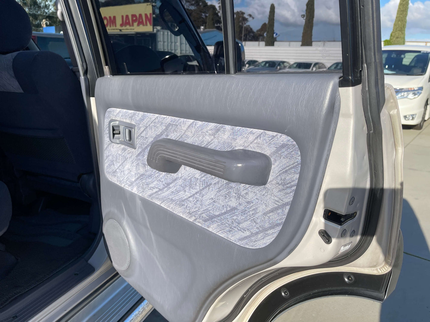 Interior door panel of a 1996 Toyota Land Cruiser Prado V6 3.4L, showcasing the design and materials.