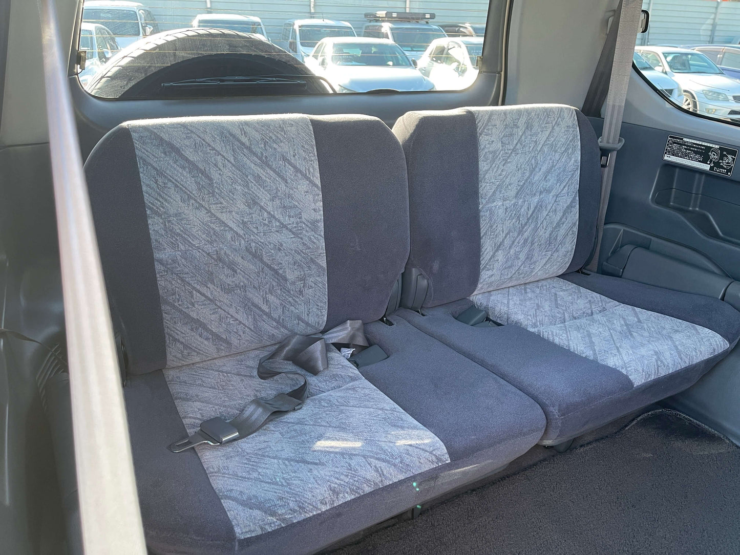 Interior view of the rear seats in a 1996 Toyota Land Cruiser Prado V6 3.4L, highlighting spacious seating for 8.