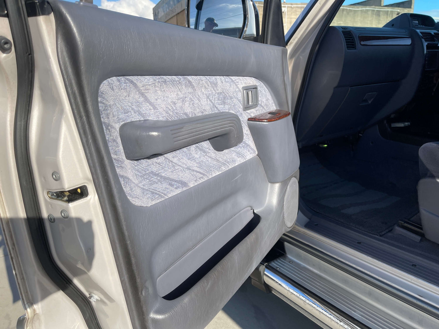 Interior view of 1996 Toyota Land Cruiser Prado V6 3.4L door panel showcasing fabric and features.