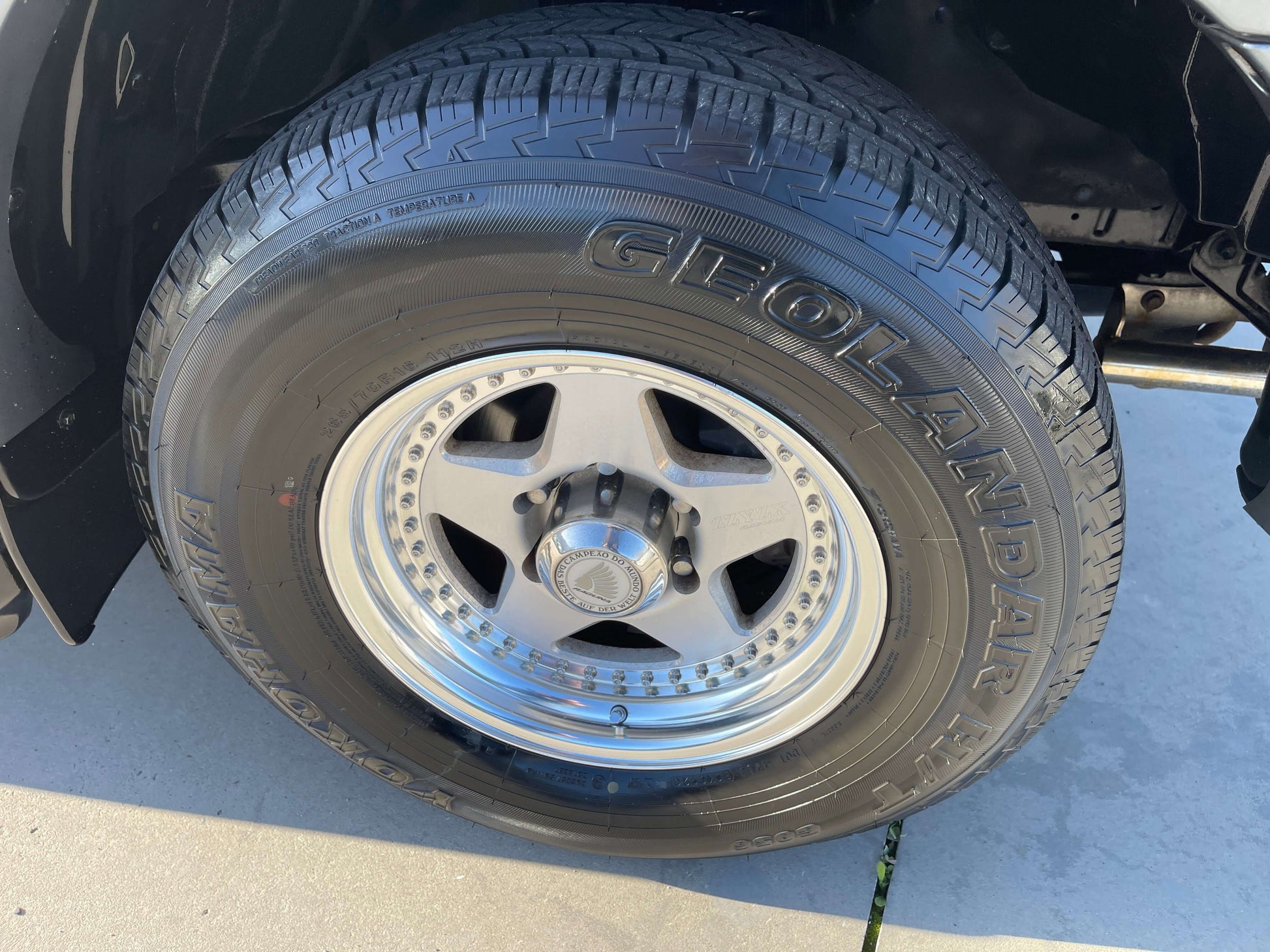Close-up of a tire and alloy wheel from a 1996 Toyota Land Cruiser Prado V6 3.4L, showcasing the GEOLANDAR brand.