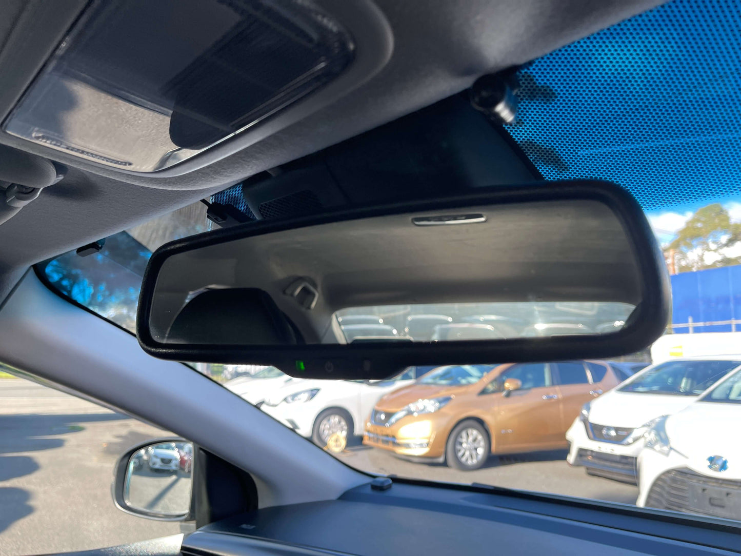 2019 Honda Grace 1.5 Hybrid Interior view of rearview mirror in a car, showcasing reflections of parked vehicles.