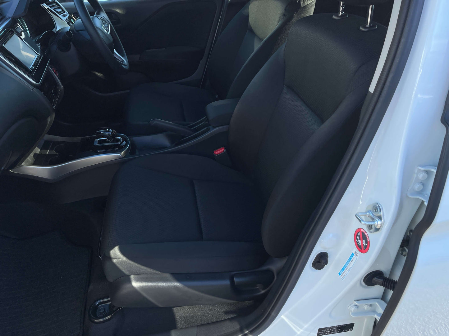 Interior view of a 2019 Honda Grace 1.5 Hybrid LX Sedan showcasing black seating and dashboard details.