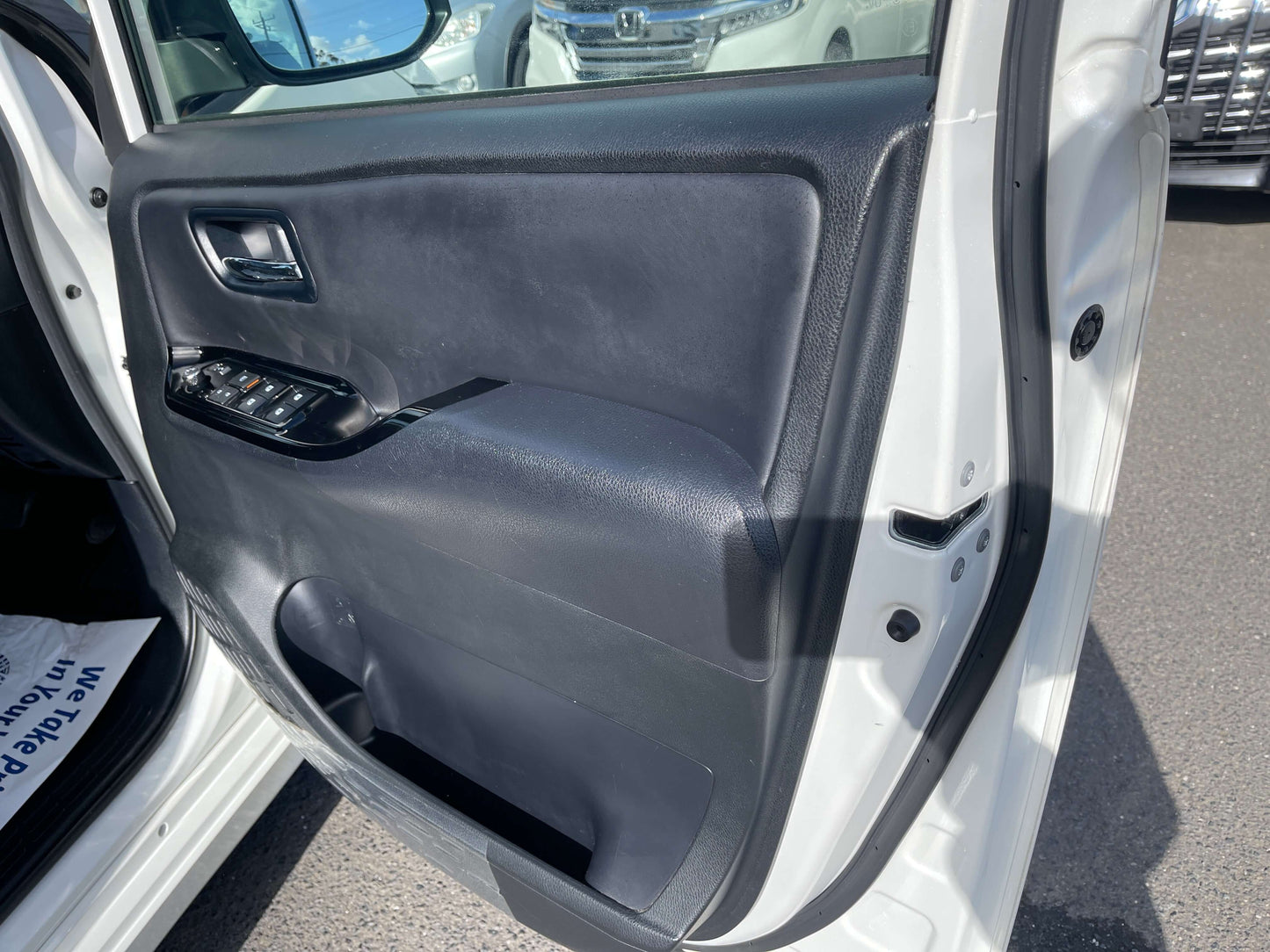 Interior view of the 2018 Toyota Noah 1.8L Hybrid G Edition door panel with control buttons.
