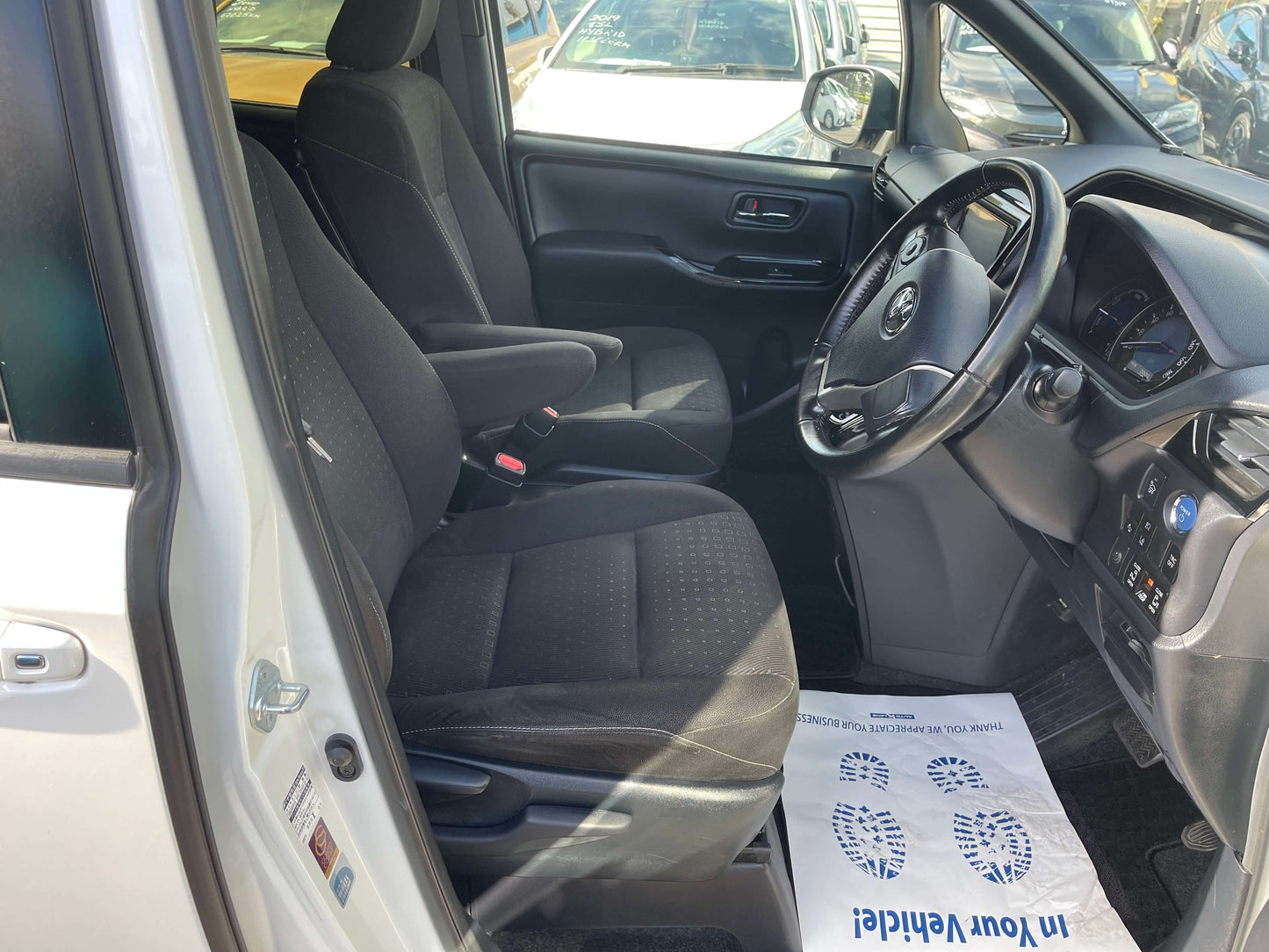 Interior view of 2018 Toyota Noah 1.8L Hybrid G Edition showing front seats and dashboard.