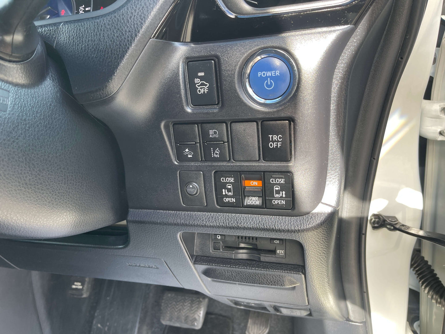 Interior controls of a 2018 Toyota Noah 1.8L Hybrid G Edition including power and traction control buttons.