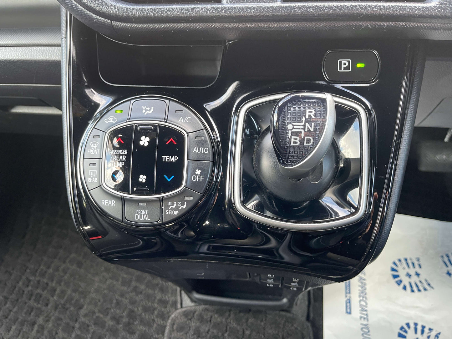 Interior controls of 2018 Toyota Noah 1.8L Hybrid G Edition showing climate and gear shift features.