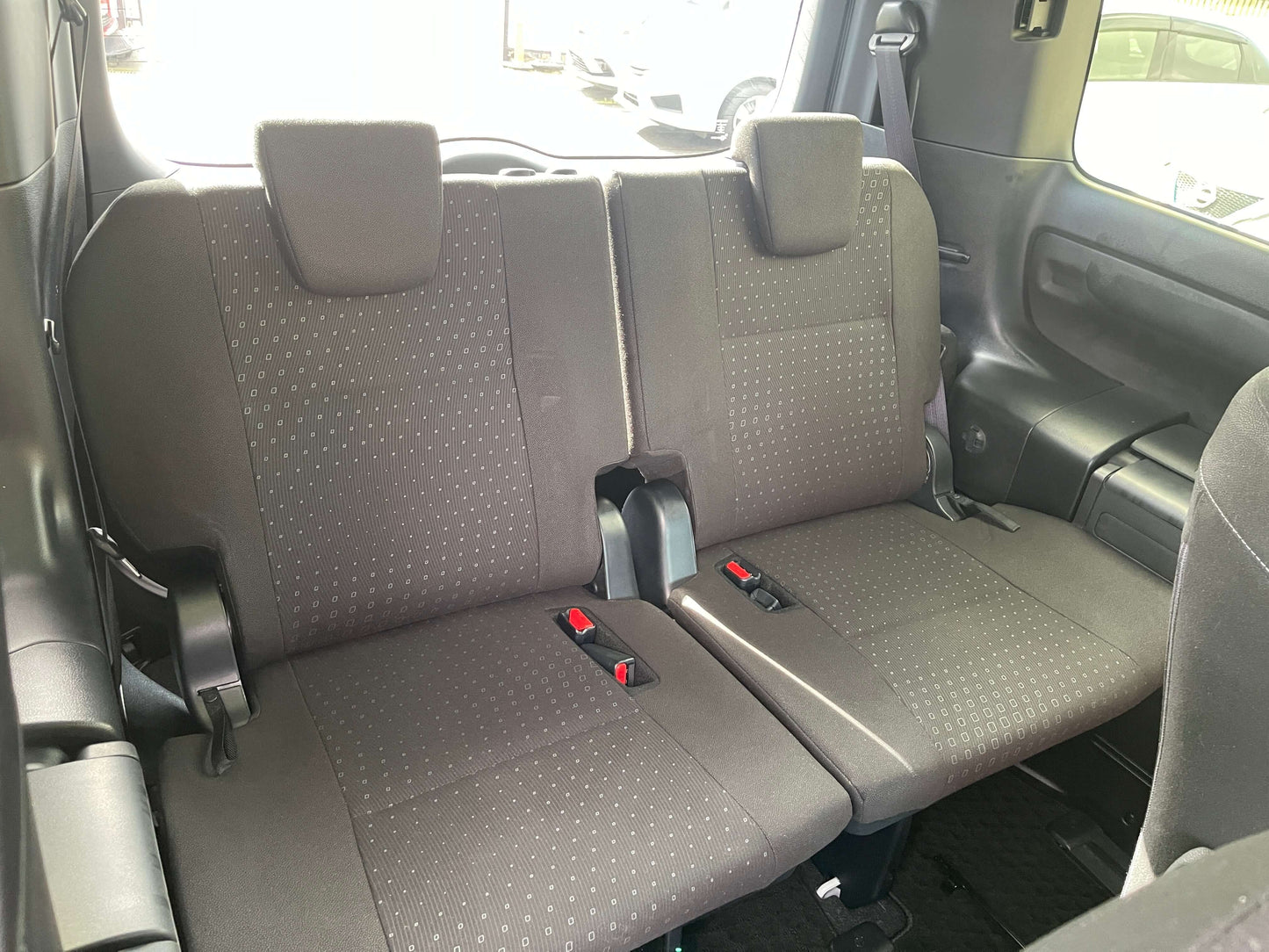 Interior view of the rear seats in a 2018 Toyota Noah 1.8L Hybrid G Edition, showcasing comfortable 7-seater layout.