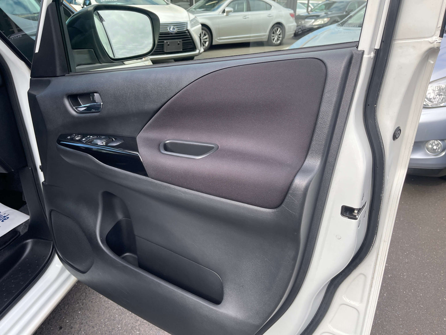 Interior view of the 2016 Nissan Serena door panel showcasing controls and materials.