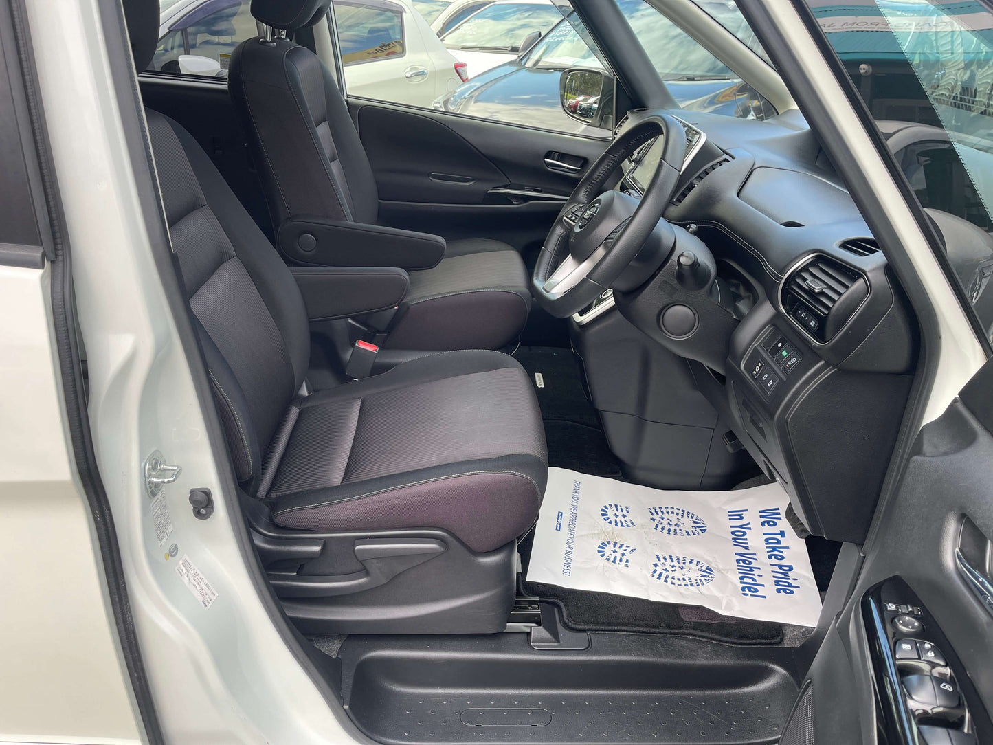 Interior view of the 2016 Nissan Serena showing front seats and dashboard, highlighting spacious design for families.