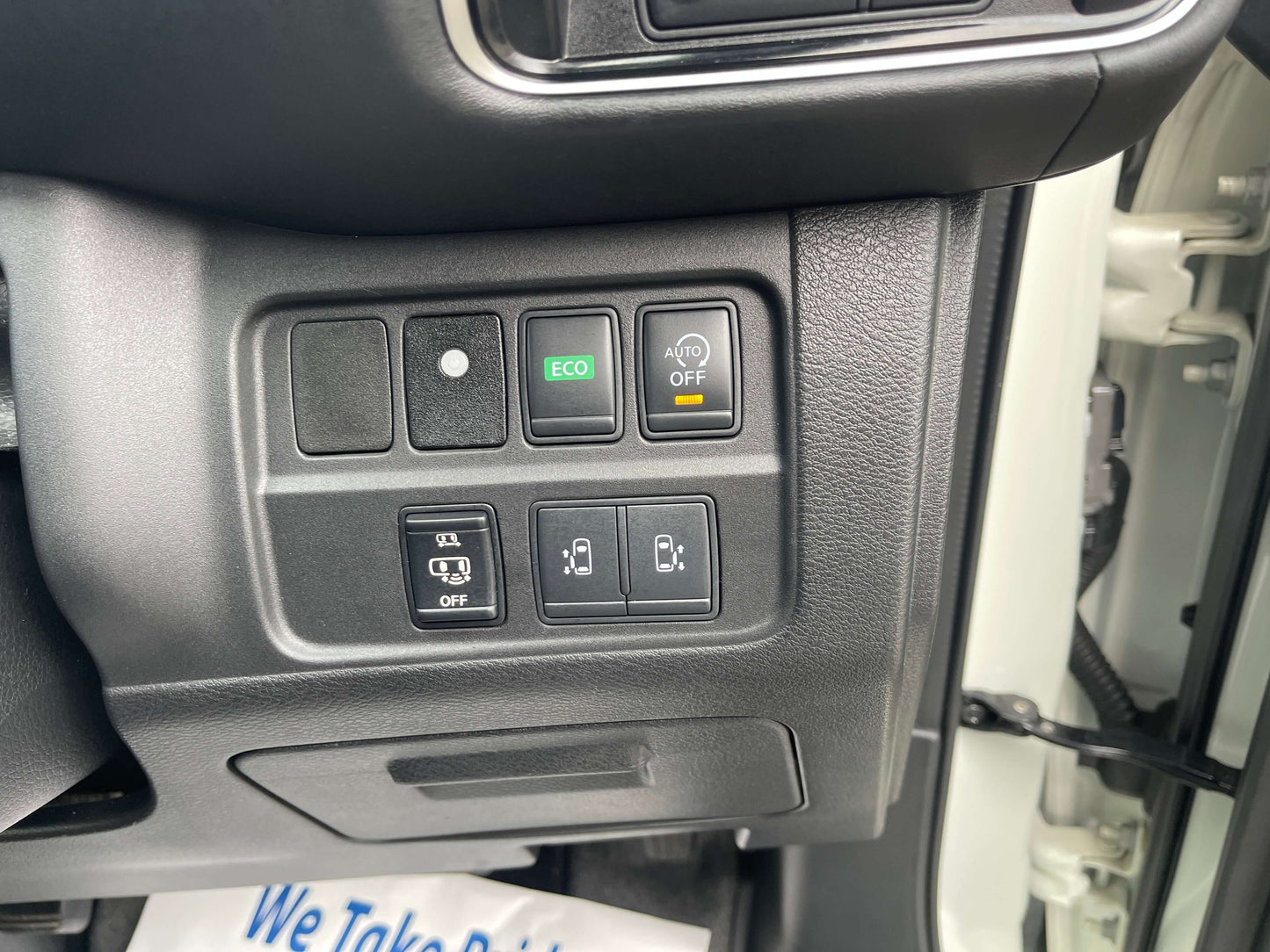 Interior control panel of a 2016 Nissan Serena with eco and lock buttons.