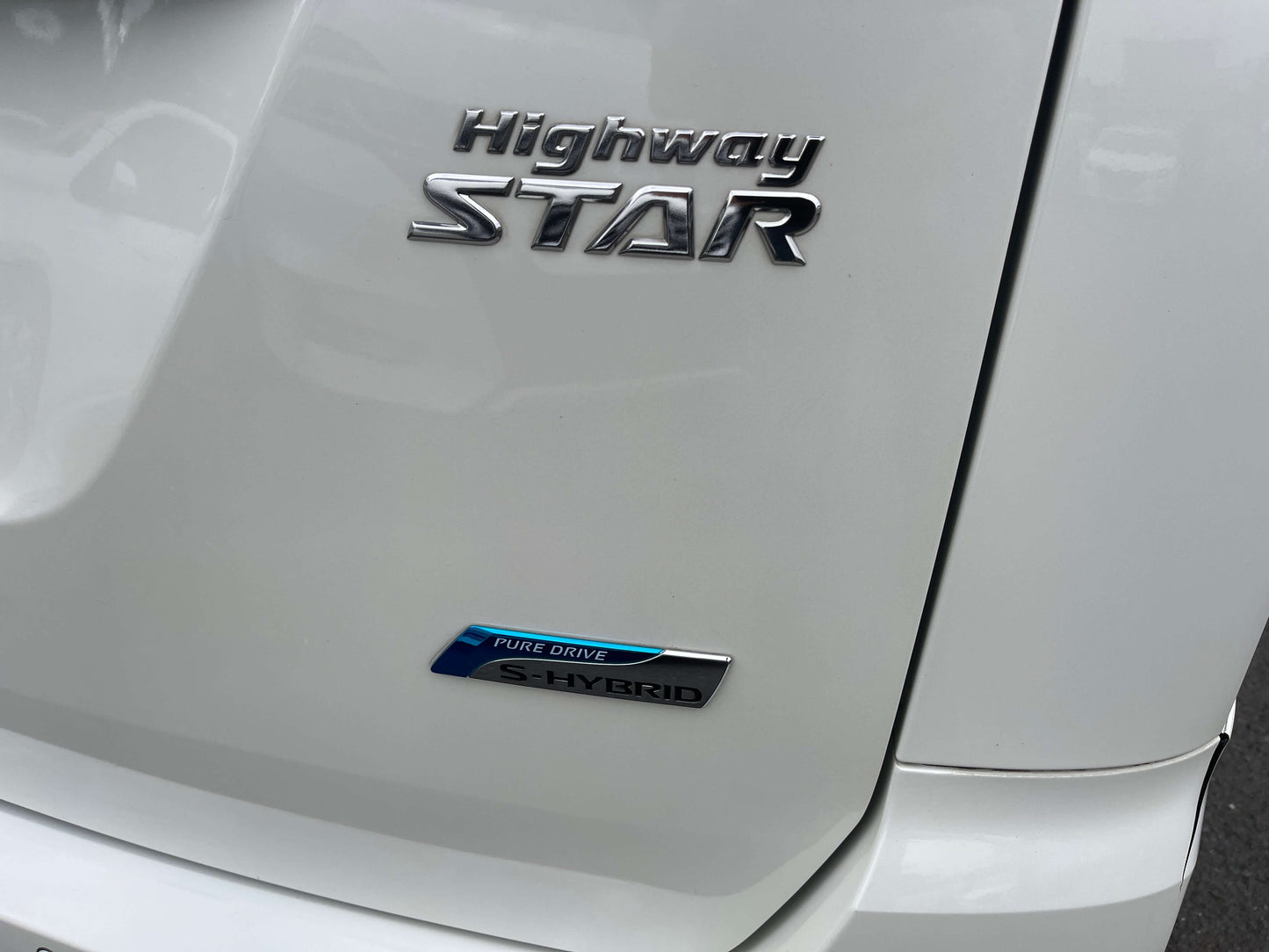Close-up of the 2016 Nissan Serena Highway Star badge and S-Hybrid emblem on a white vehicle.