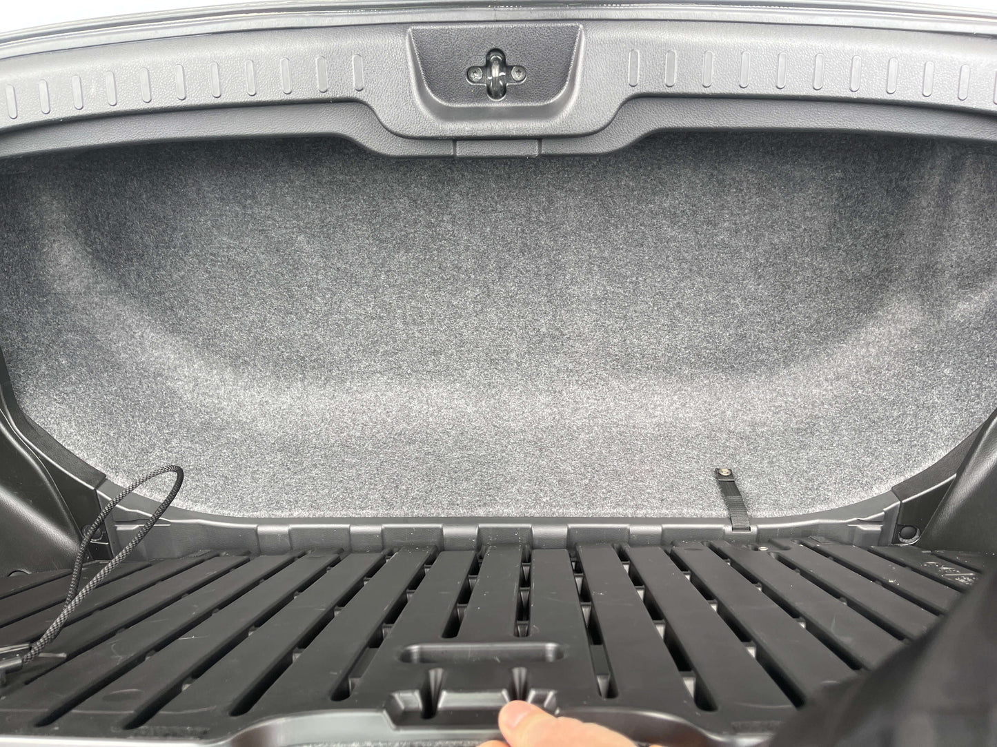 Interior view of the 2016 Nissan Serena trunk space with gray carpeting and storage features.