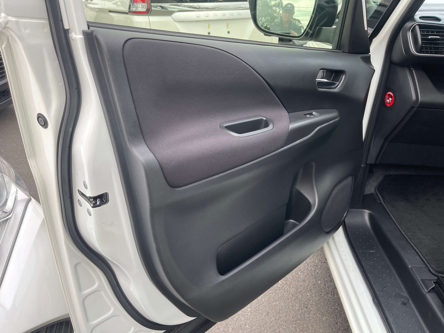 Interior detail of 2016 Nissan Serena driver's door, showcasing the door panel and handle.