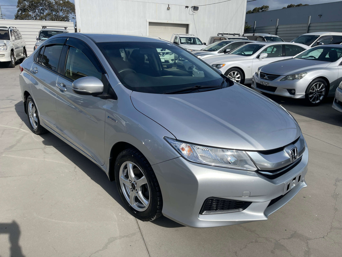 2015 Honda Grace 1.5 Hybrid DX Sedan in silver color parked outdoors, showcasing its sleek design and modern features.