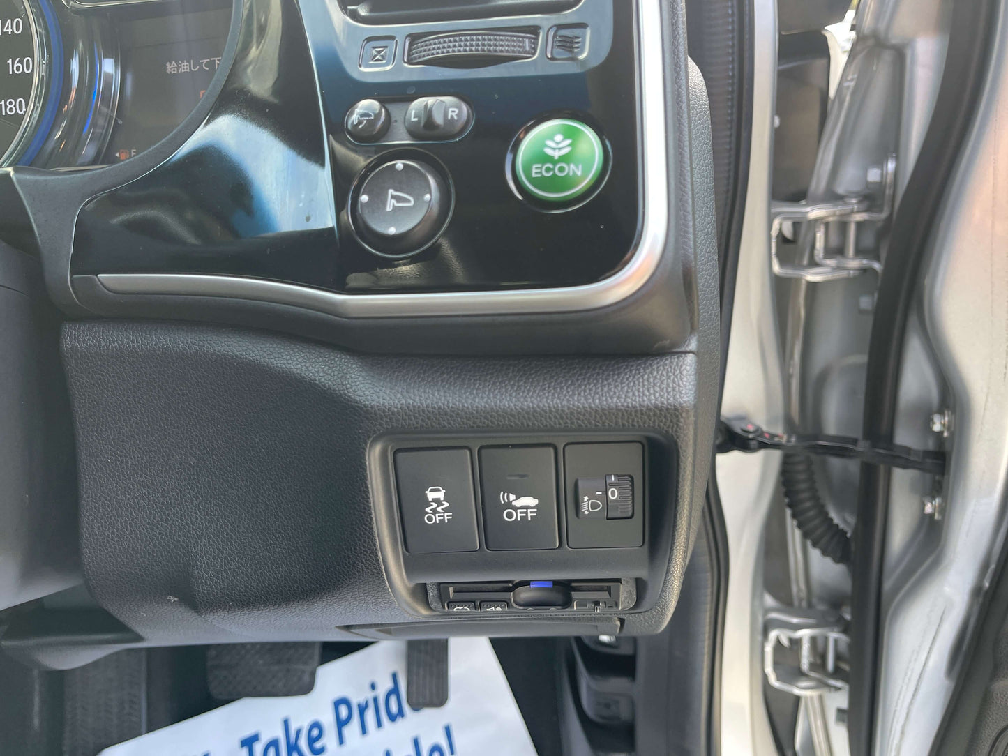 Interior controls and ECO button in the 2015 Honda Grace 1.5 Hybrid DX Sedan, showcasing efficient vehicle features.