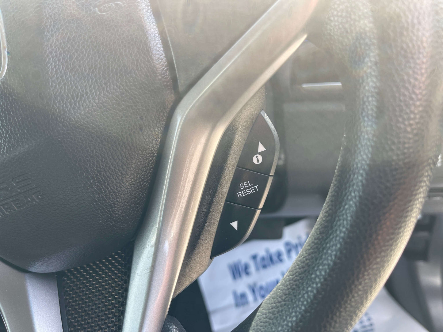 Close-up of the steering wheel controls in a 2015 Honda Grace 1.5 Hybrid DX Sedan, focusing on the 'SEL' and 'RESET' buttons.