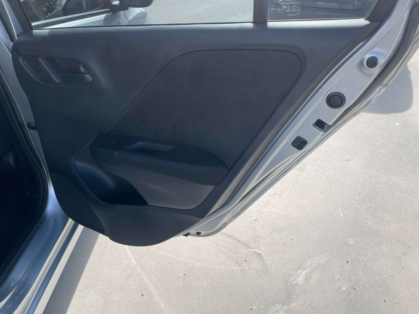 Interior view of the driver's side door of a 2015 Honda Grace 1.5 Hybrid DX Sedan, showcasing the door panel design.
