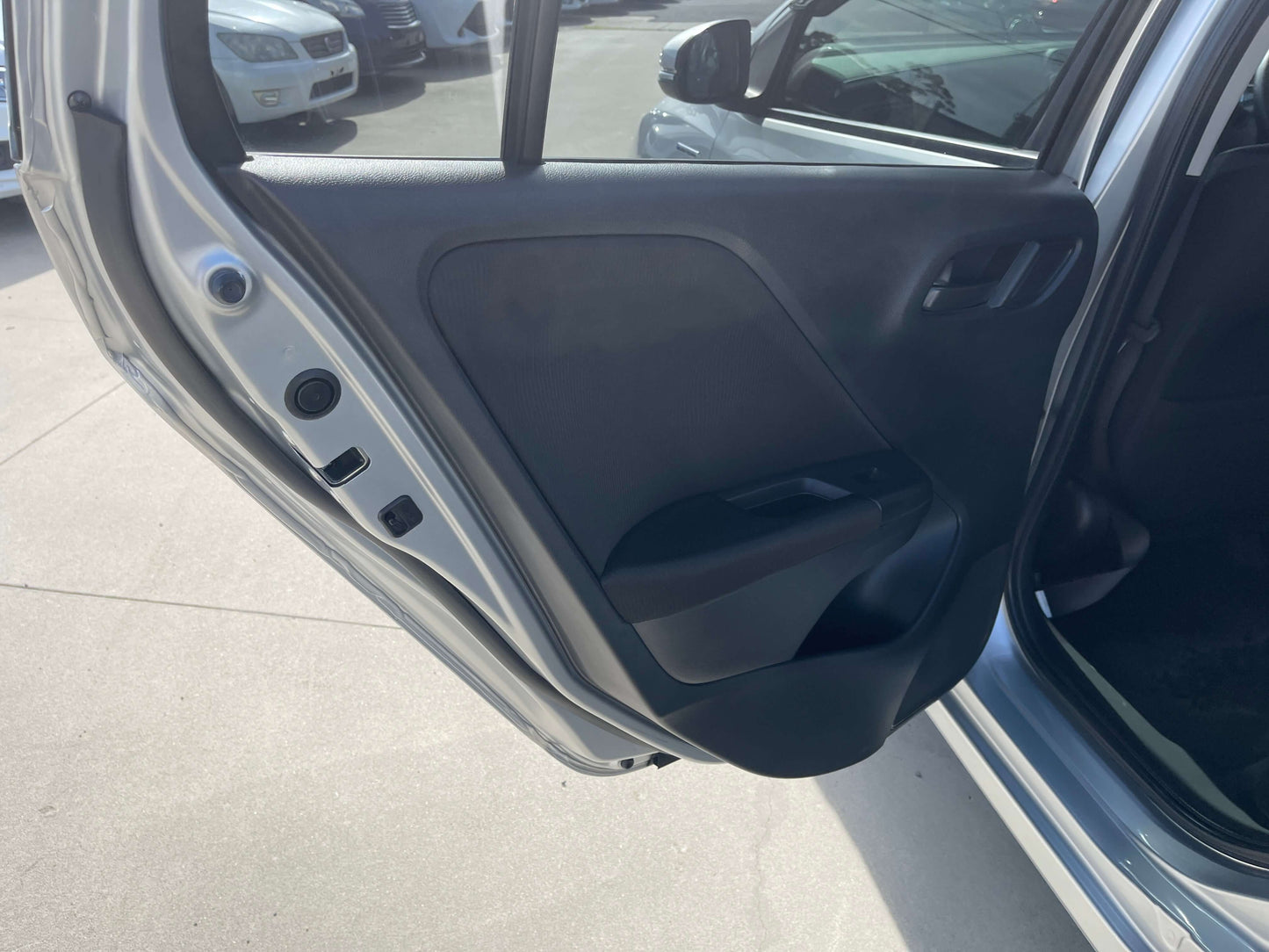 Interior view of the 2015 Honda Grace 1.5 Hybrid showing the rear door design and handle.