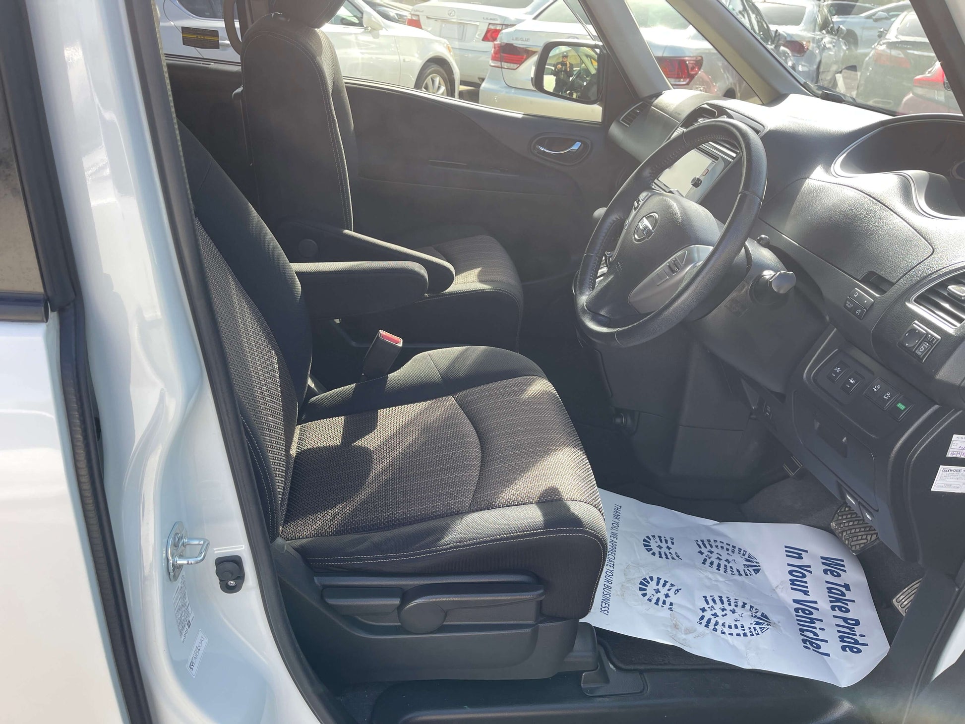 Interior of 2016 Nissan Serena showing front seats and dashboard with 8-seater configuration.