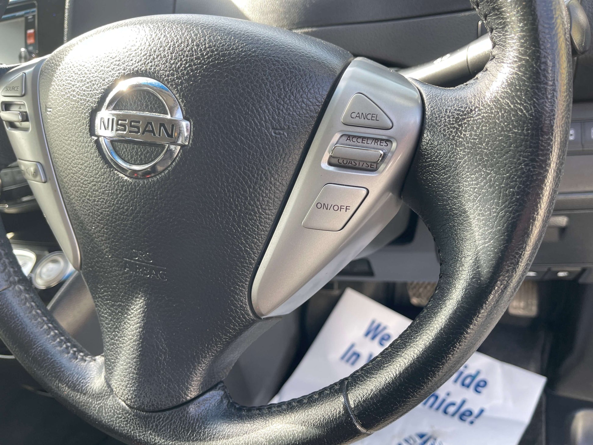 Steering wheel controls of 2016 Nissan Serena with Nissan logo and buttons for cruise control and audio settings.
