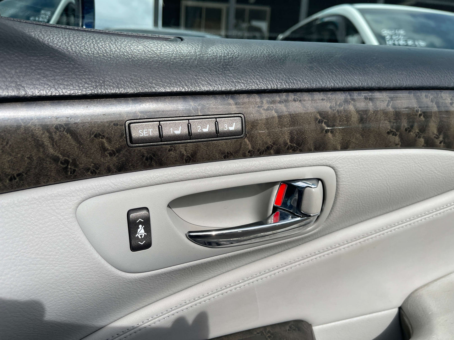 Interior door panel of a 2006 Lexus LS460 V8 4.6L showing controls and luxury finishes.