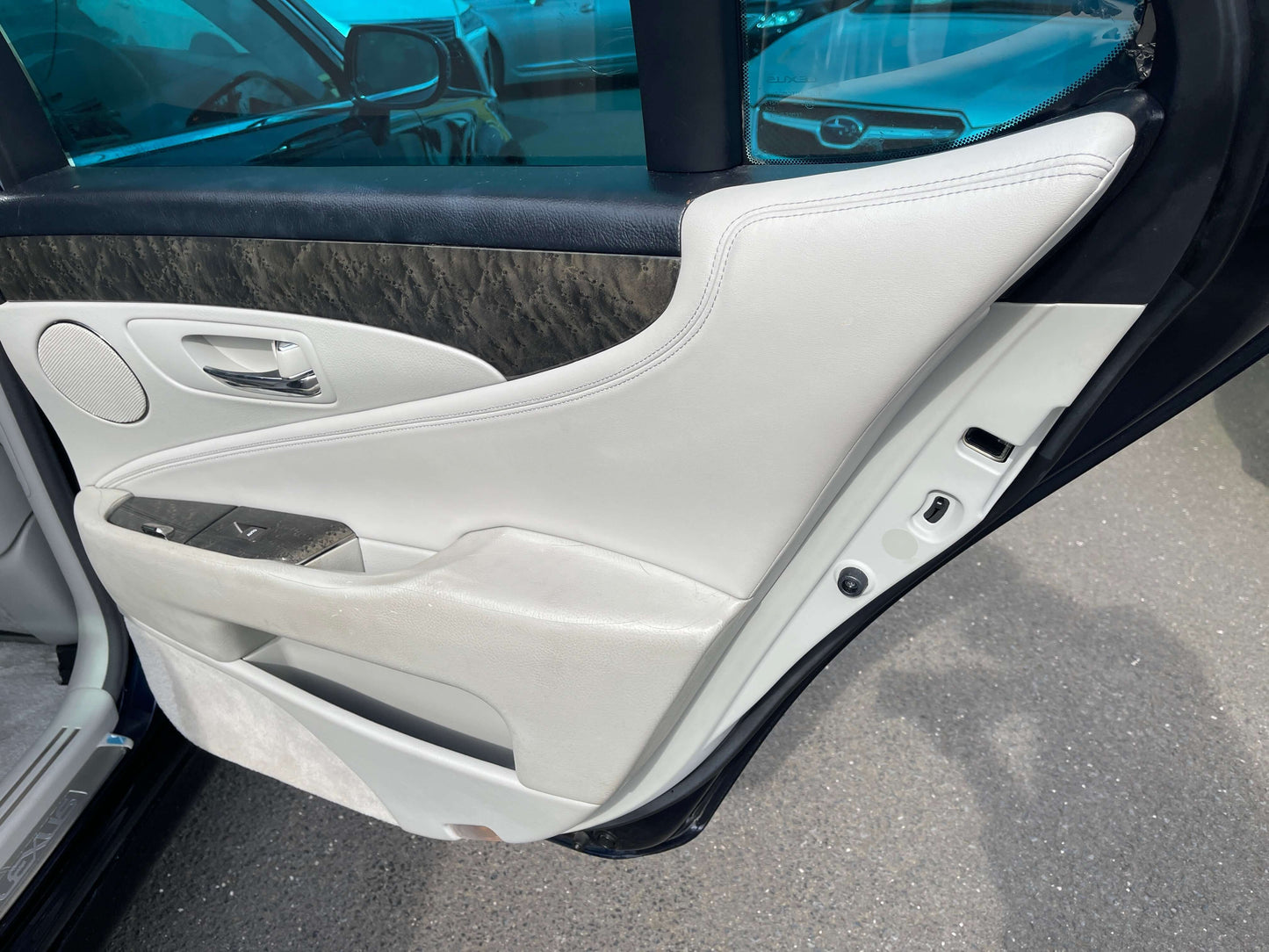 2006 Lexus LS460 V8 4.6L I Package premium luxury sedan door interior with white leather and wood trim.