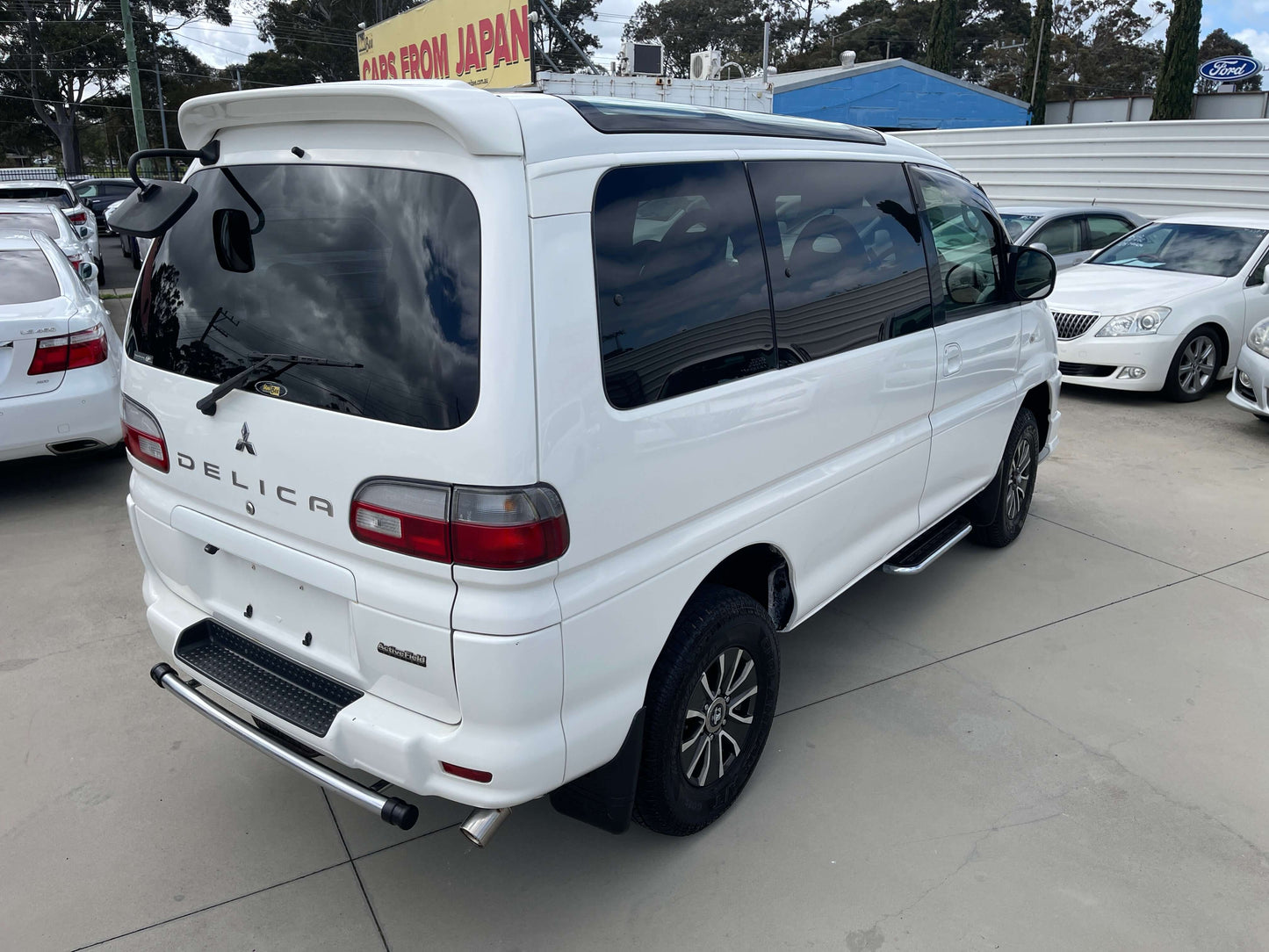 2006 Mitsubishi Delica rear view in white, featuring Skylite roof and 4WD capabilities.