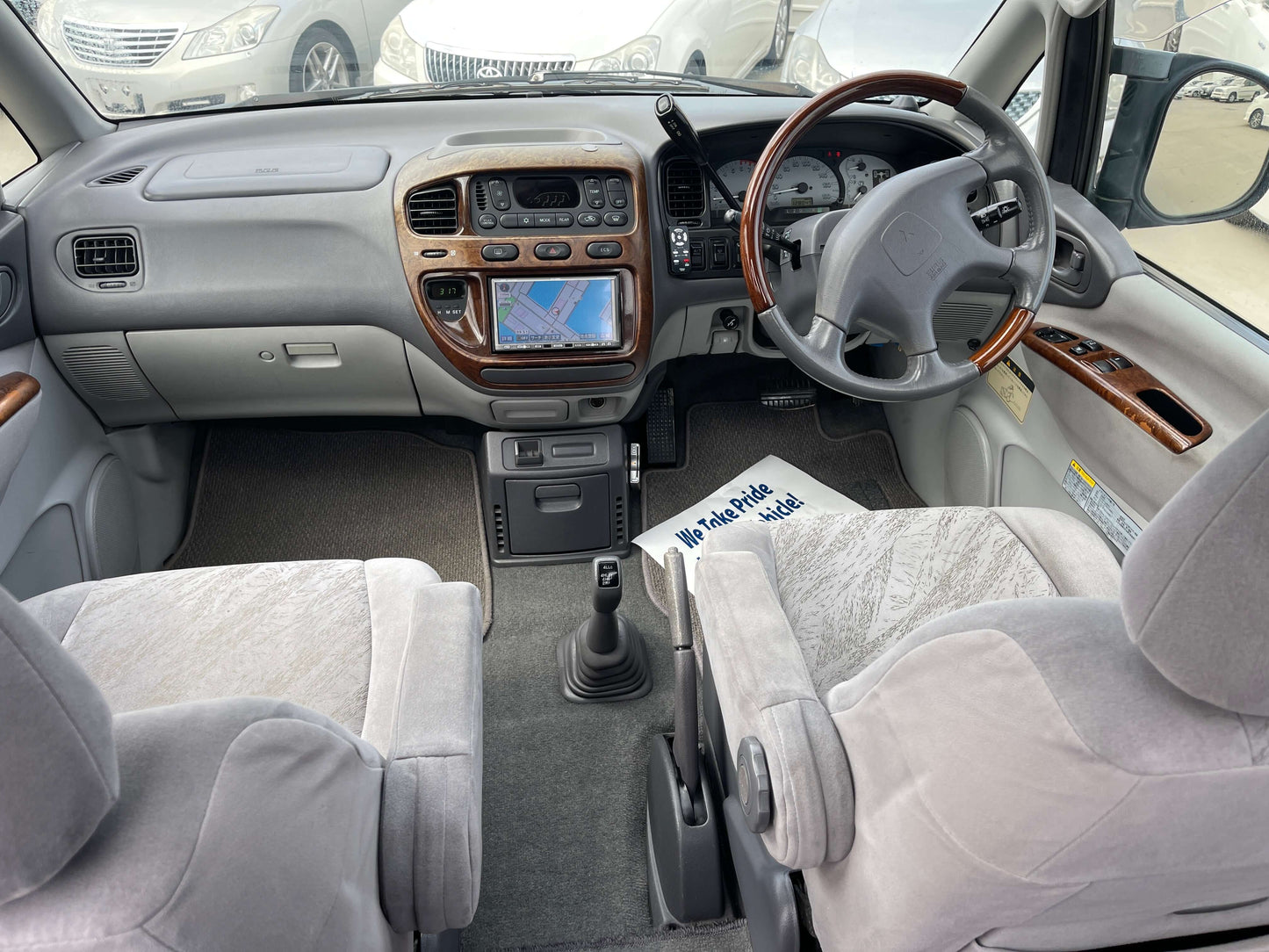 Interior view of a 2006 Mitsubishi Delica showing dashboard, seats, and controls in a spacious design.